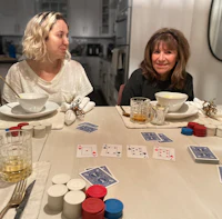 two women sitting at a table playing cards