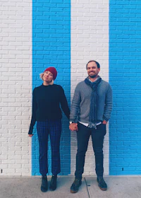 a man and woman standing in front of a blue and white wall