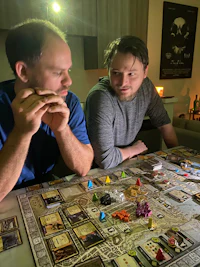 two men sitting at a table playing a board game