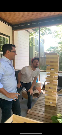 two men playing a game of dominoes on a patio